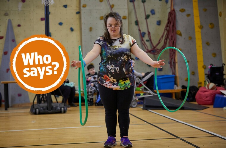 Girl with Down's syndrome playing with two green hula hoops 