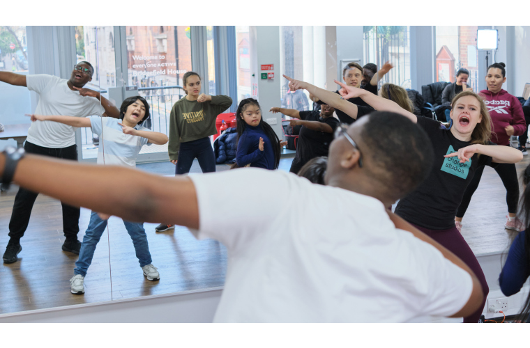 Dance teacher leading a dance class for young disabled people