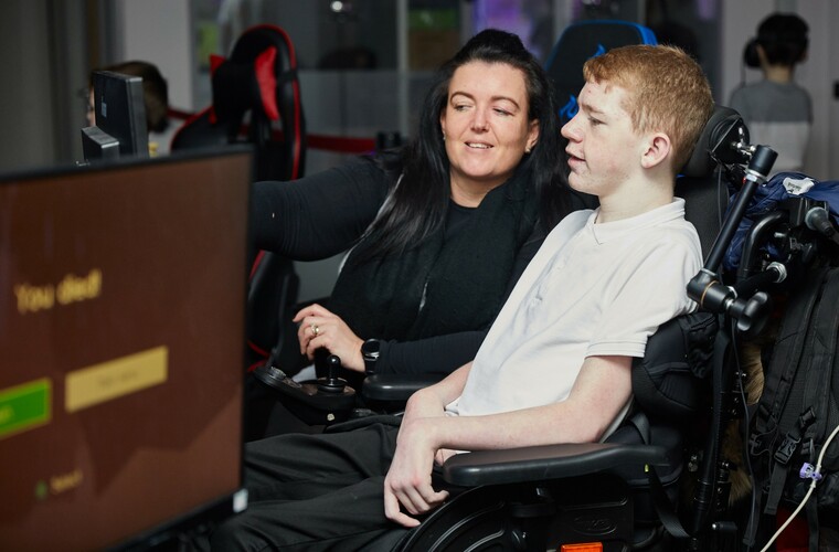 Mum supporting her son to take part in an inclusive gaming session
