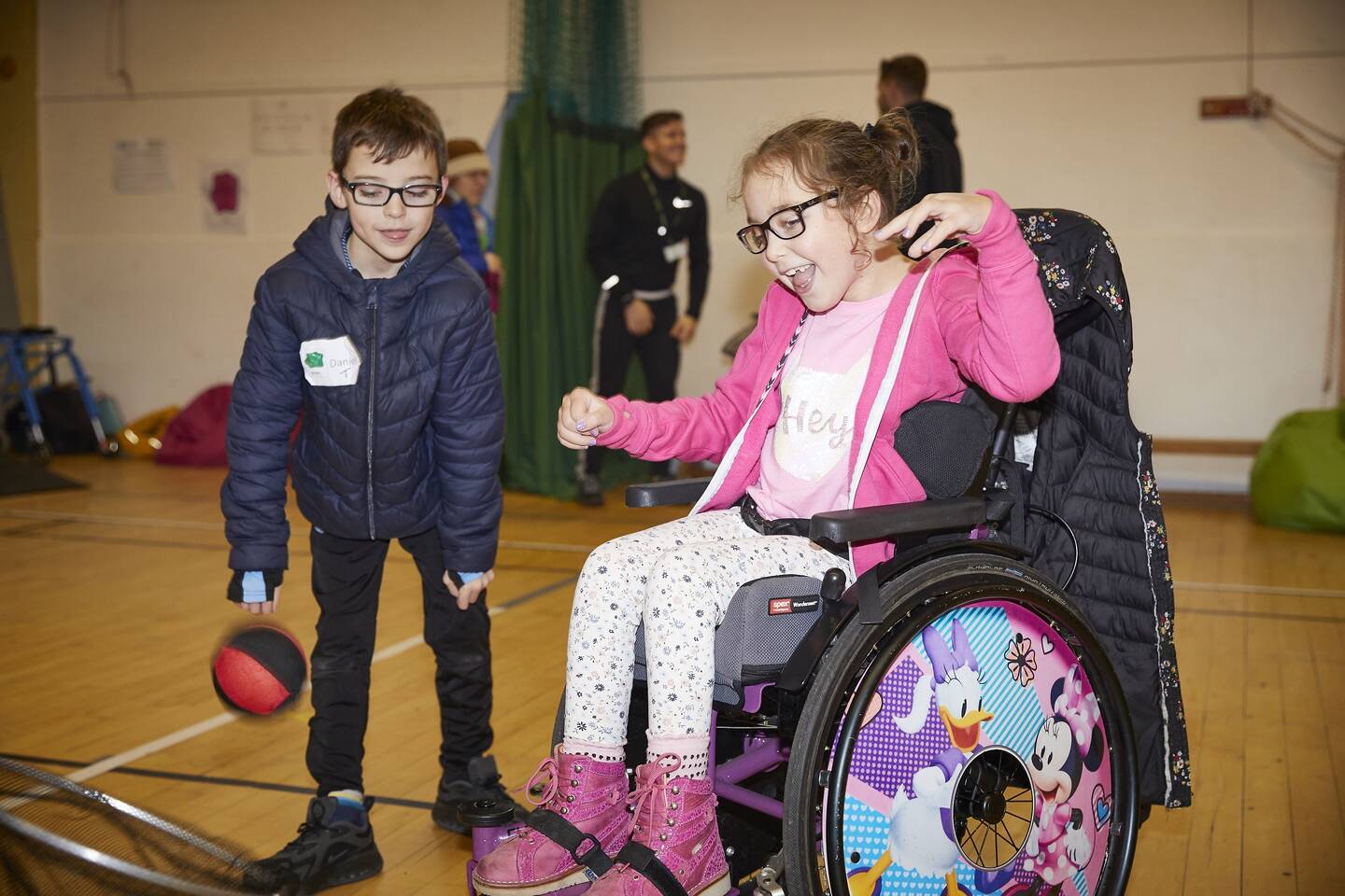 A disabled girl with her brother playing with a ball