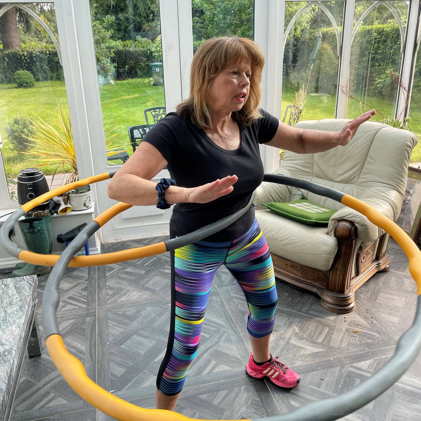 Sue hula-hooping in her living room