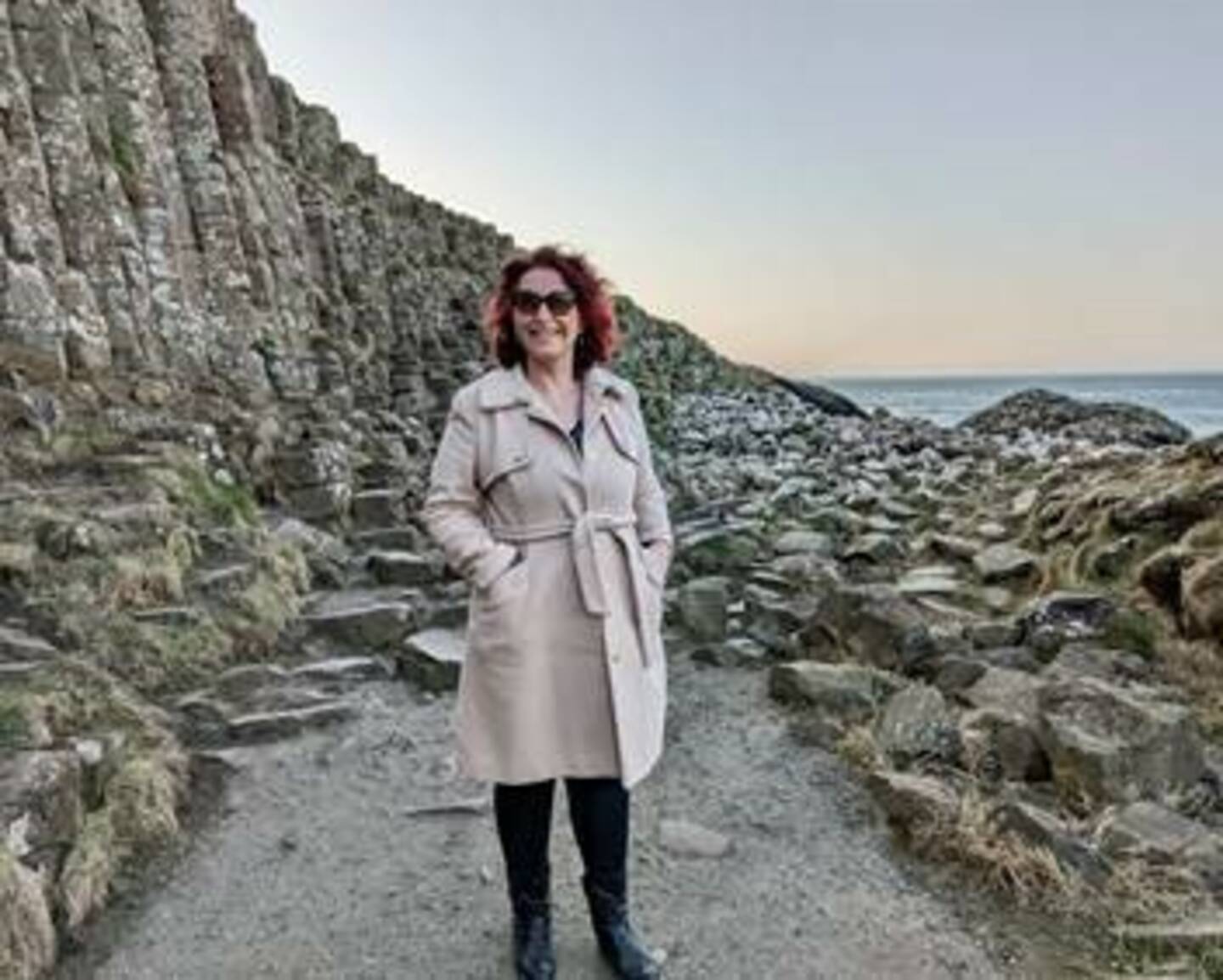 Jane smiling to camera on a coastal walk 