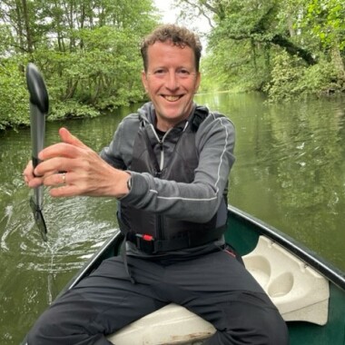Barry in a boat rowing on a river