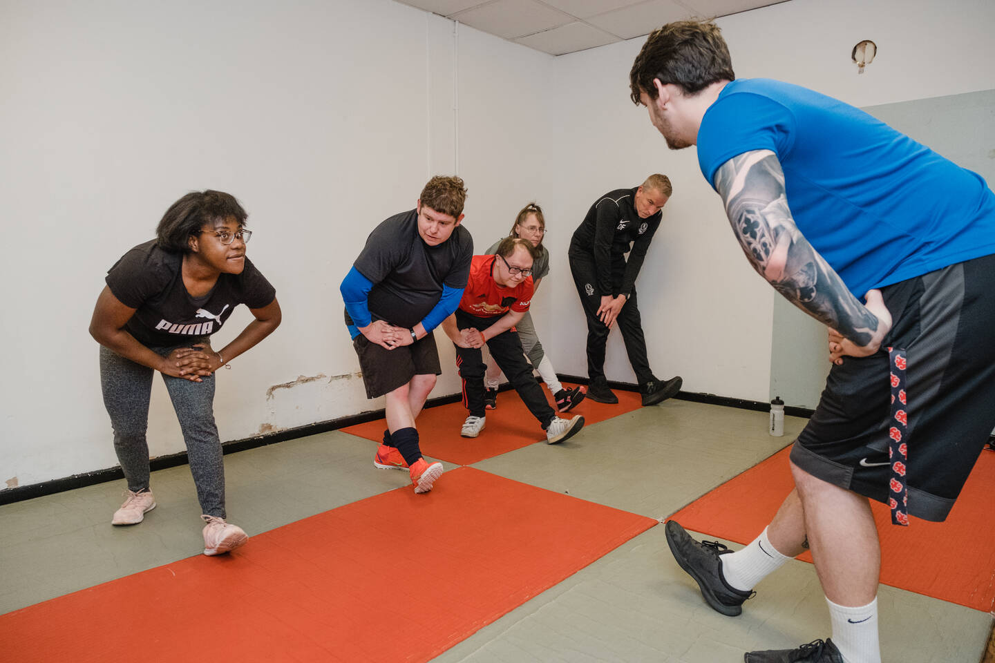 Group of disabled people doing leg stretches during a group PT session