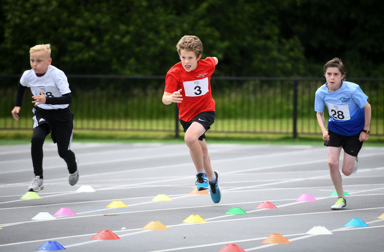 3 athletes taking part in 100m race at National Junior Athletics Championships 2022