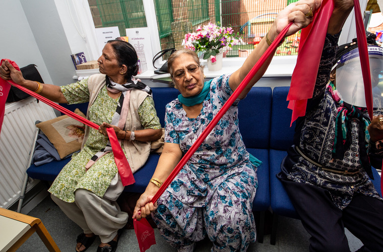 Two older women doing a seated exercises at a GOGA session in Wolverhampton.