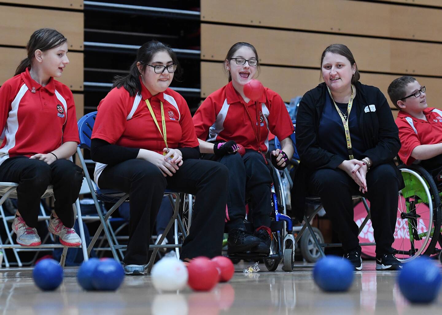 A group of disabled girls sat with their coach playing a game of boccia.
