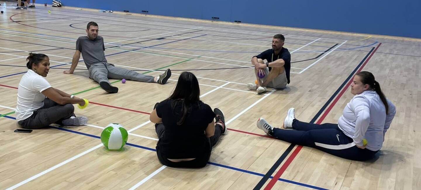 Group of tutors sitting on the floor taking part in inclusion training