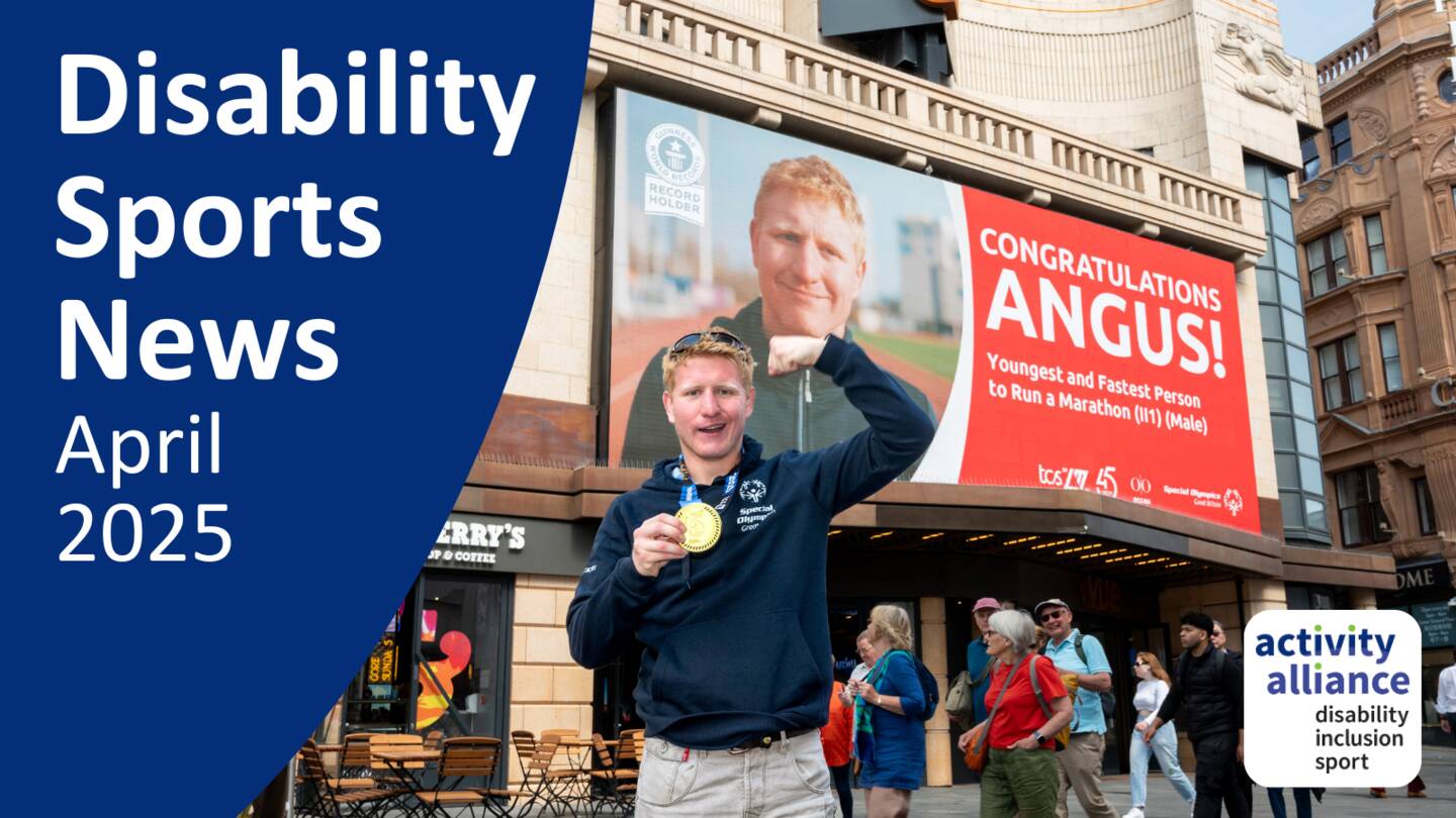 A photograph of Angus Leckonby after the London Marathon. He has the medal around his neck and he is standing in front of a billboard with the words 'Congratulations Angus' and his picture on it.