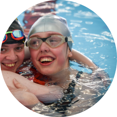 Two swimmers hugging after a race