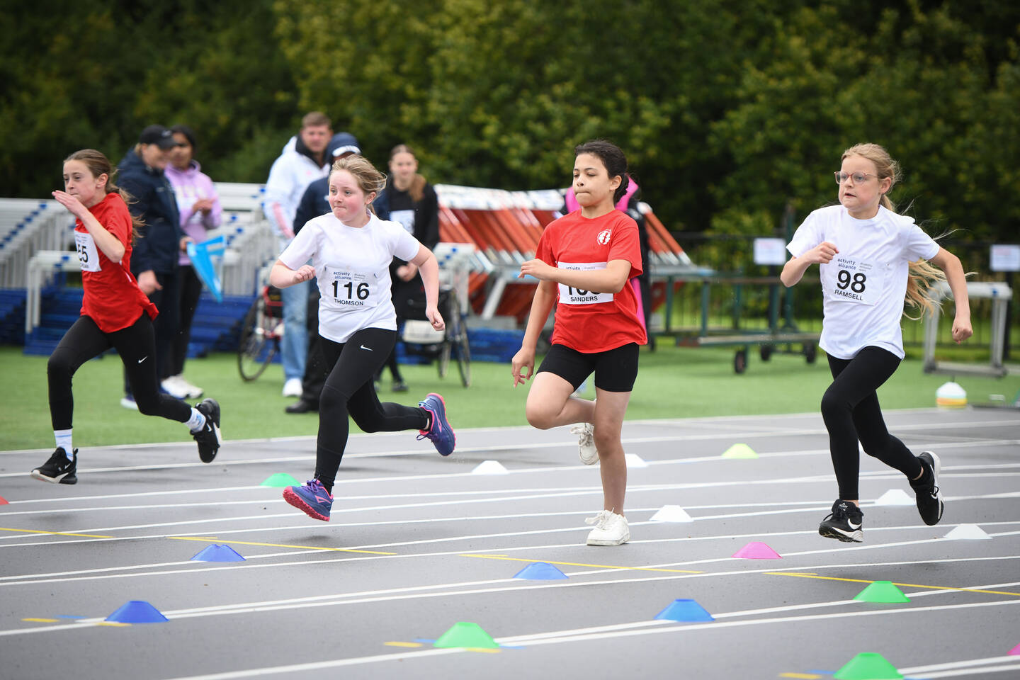 A group of people run on a running track.