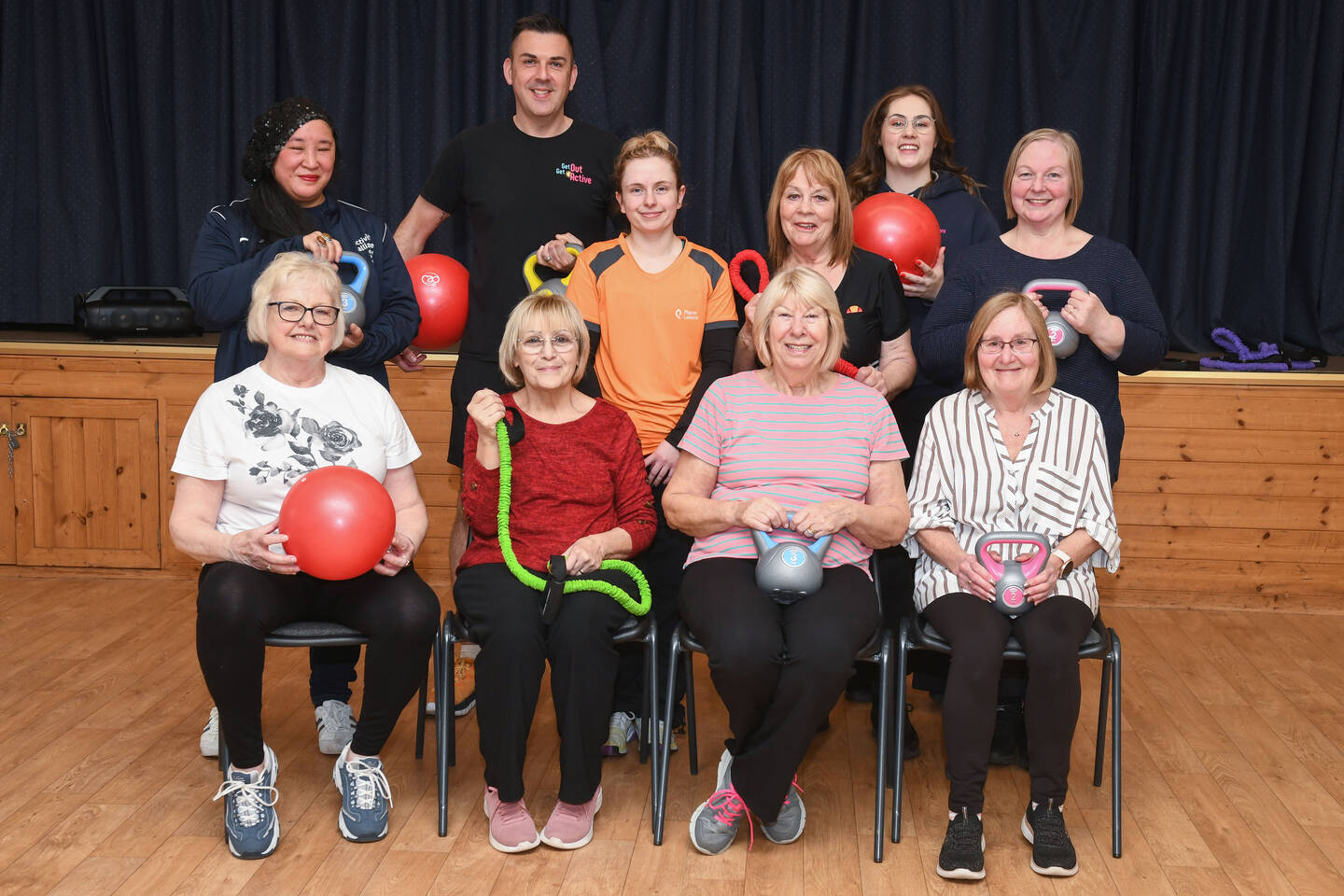 A group smile in a community hall.
