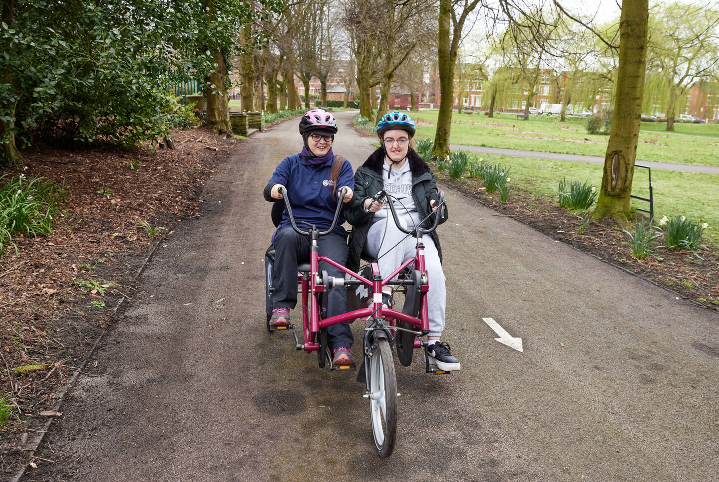 Two people sit on an adapted trike.