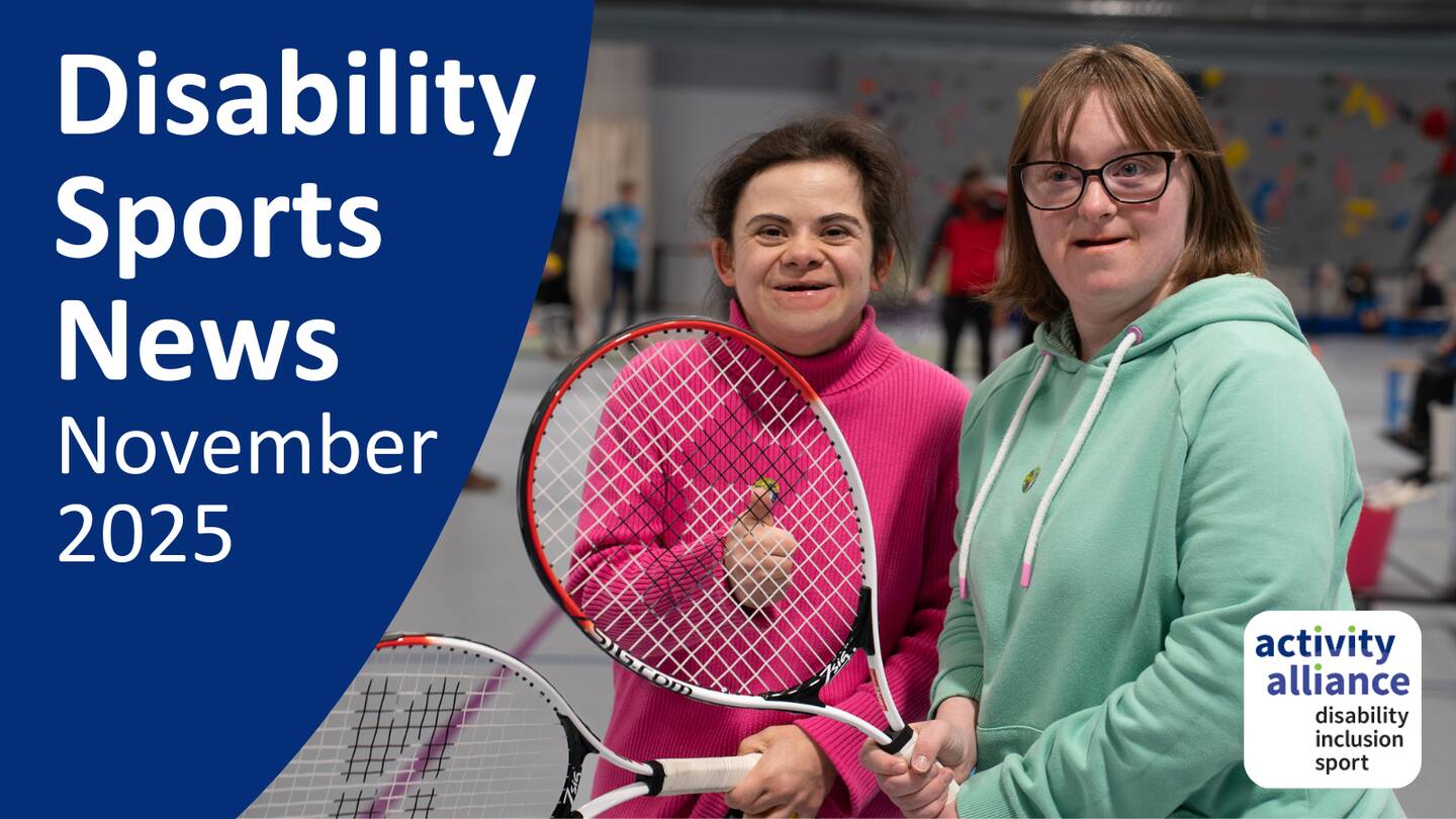 Two disabled women holding rackets in a sports hall and smiling at the camera