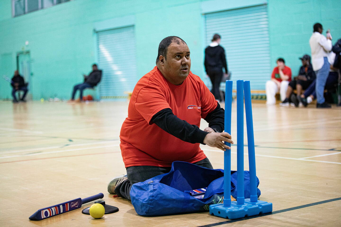 A volunteer puts out some cricket stumps.