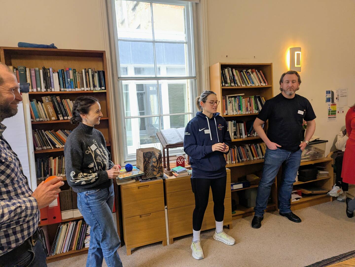 A group of people from the The Centre for Sustainable Healthcare team stand in a circle in a room.
