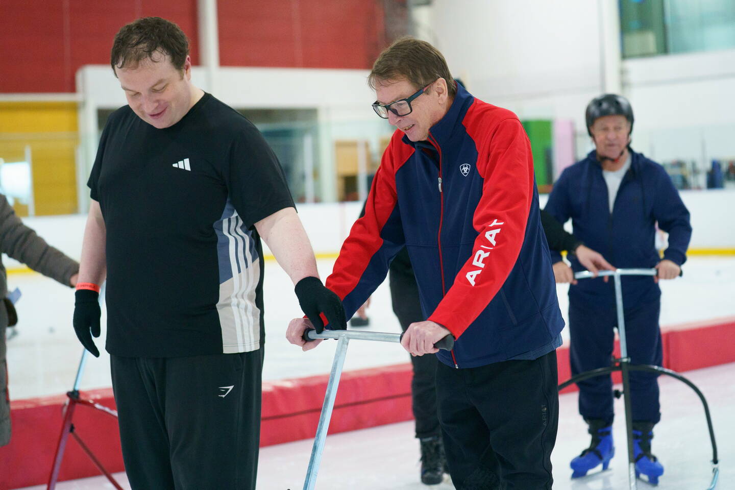 An inclusive ice skating session - skaters enjoy a session on the ice supported with frames and volunteers.