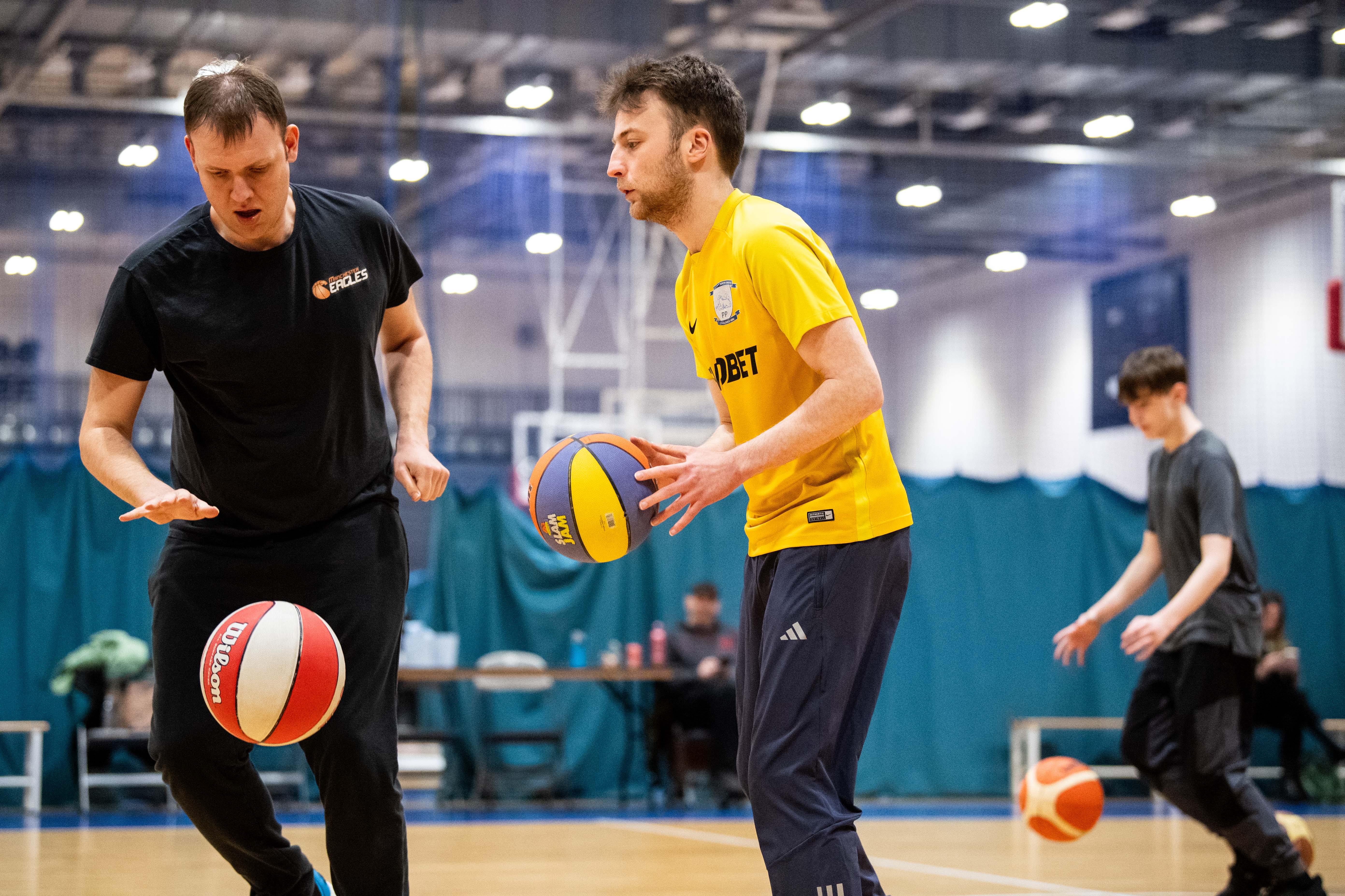 Two disabled men play basketball in a sports hall