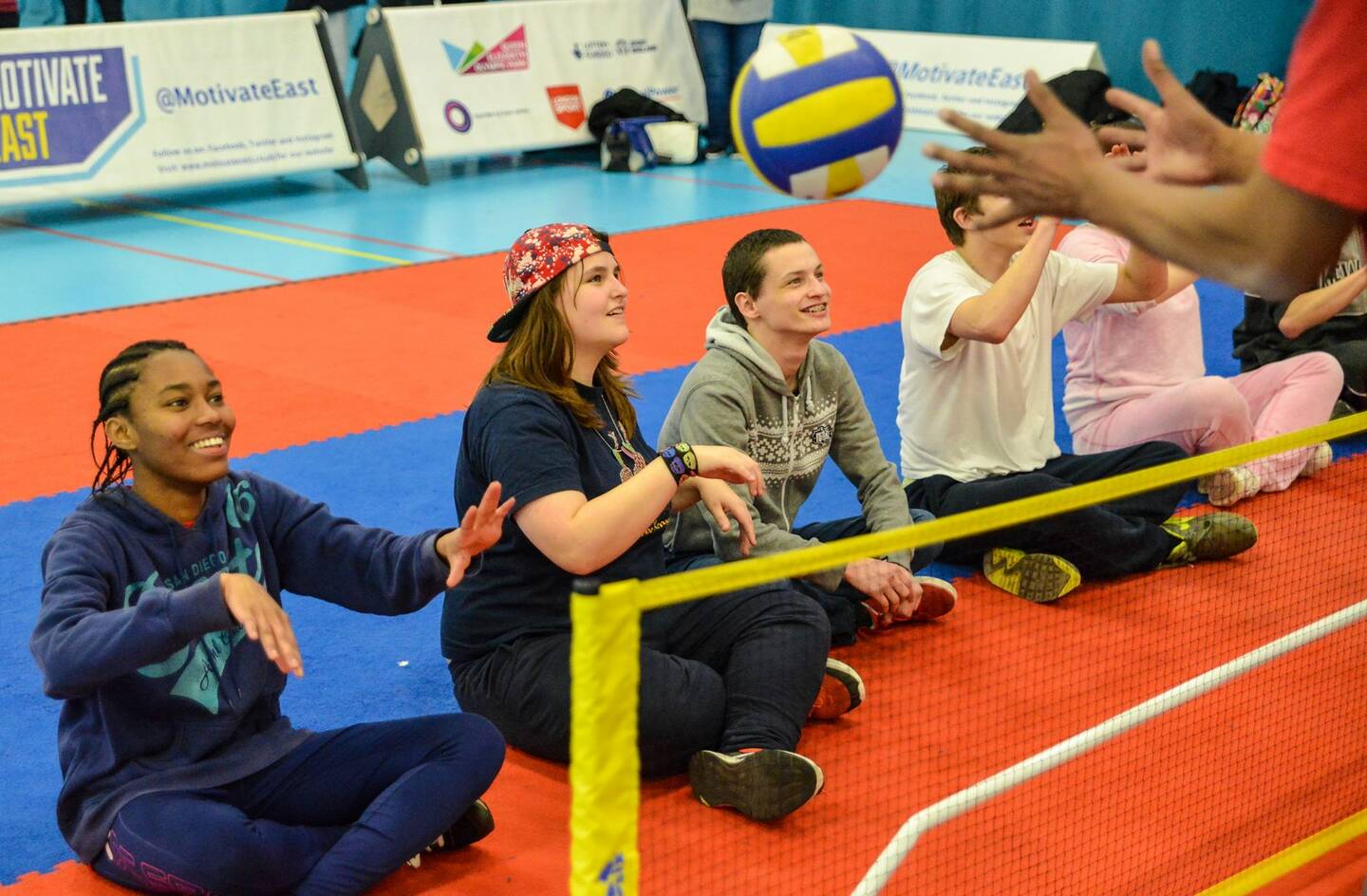 Young disabled people playing sitting volleyball